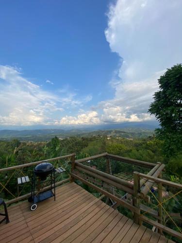 a chair sitting on a wooden deck with a view at Glamping Resort Jonico Finca in Chinchiná
