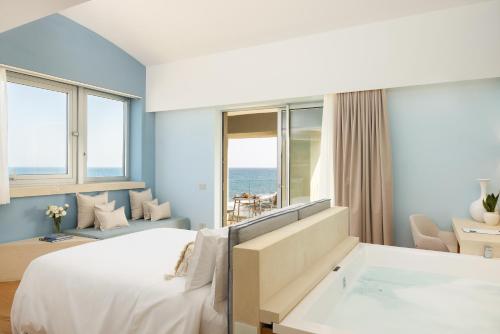 a hotel room with a bed and a view of the ocean at Metamare in Cozze
