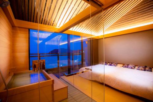 a bedroom with a bed and a large window at シーサイド佐竹 in Kyotango