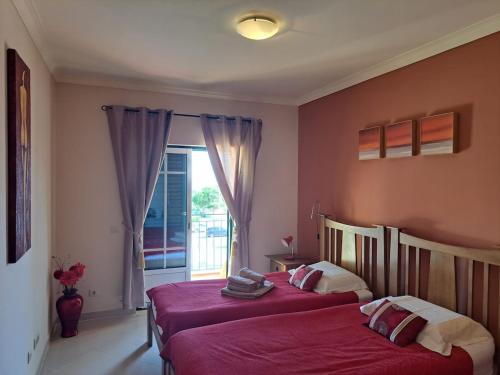 two beds sitting in a room with a window at Sunset Apartment in Porches