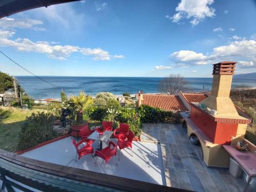 a view of a patio with red chairs and a fireplace at Villa Velika GR in Velika