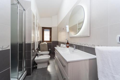 a bathroom with a sink and a toilet and a mirror at B&B Golden House & spa in Rose