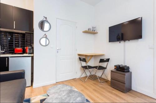 une cuisine avec une table et des chaises dans une pièce dans l'établissement 1 Cozy studio Père Lachaise Nation, à Paris