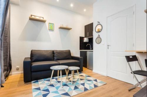 un salon avec un canapé et deux tables dans l'établissement 1 Cozy studio Père Lachaise Nation, à Paris