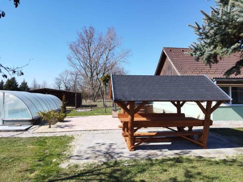a picnic table with a solar roof on it at Nyugalom Szigete Vendégház in Bócsa