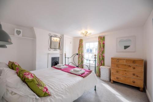 een slaapkamer met een bed, een ladekast en een raam bij Shrimpers, Southwold in Southwold