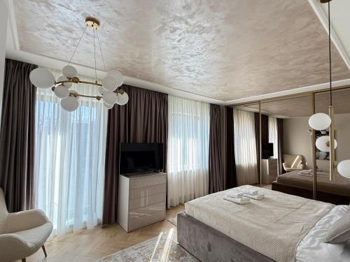 ein Schlafzimmer mit einem großen Bett und einem Fernseher in der Unterkunft COZY Luxury Collection - PREMIUM APARTHOTEL in Braşov