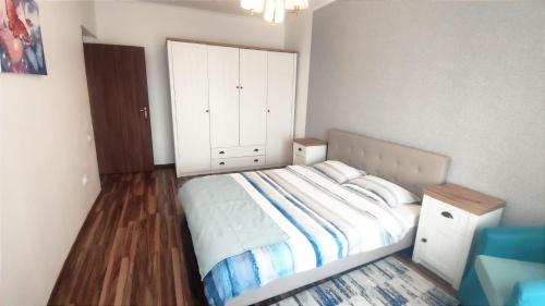 a bedroom with a bed and a large white cabinet at Charming apartment in villa Ap2 in Iaşi