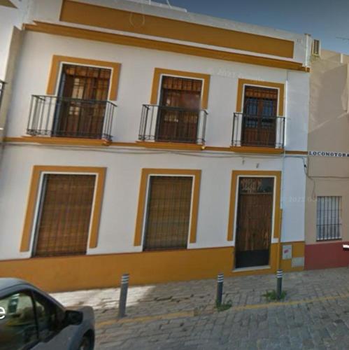 a building with windows and a car parked in front of it at Apartamento Centro Alfonso XII in Seville