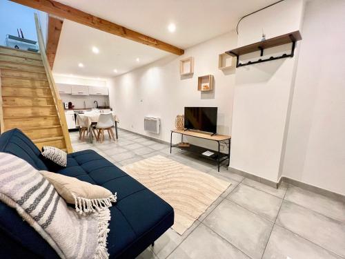 a living room with a blue couch and a television at O Nid'Istres - Centre Historique, Spacieux Studio Duplex, Wifi, 4 personnes in Istres