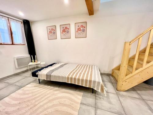 a bedroom with a bed and a wooden staircase at O Nid'Istres - Centre Historique, Spacieux Studio Duplex, Wifi, 4 personnes in Istres
