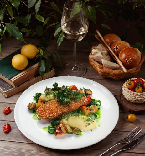 a plate of food on a table with a glass of wine at Hotel Restauracja Tenis Kortowo in Poznań