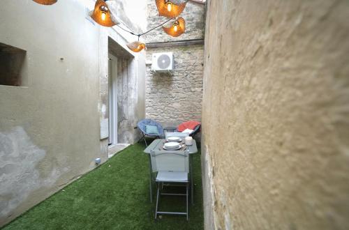 une allée avec une table et des chaises dans un bâtiment dans l'établissement Wild Room Spa & cour privée au cœur de Montpellier, à Montpellier
