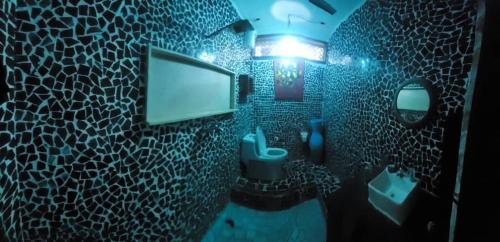 ダル・エス・サラームにあるBagamoyo home stayのバスルーム(トイレ付)、壁にテレビが備わります。