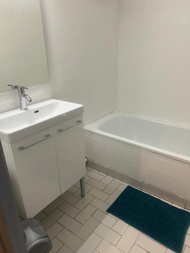 une salle de bain blanche avec un lavabo et une baignoire dans l'établissement T2 Toulouse proche Zenith, à Toulouse