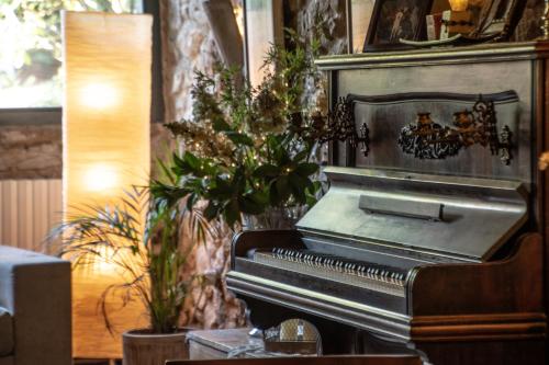 an old piano in a room with a plant at El Racó de Madremanya - Adults only in Madremanya