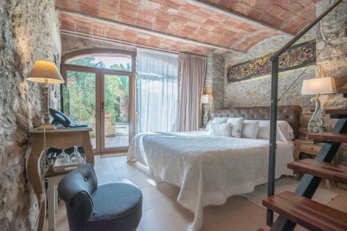 a bedroom with a bed and a chair in a room at El Racó de Madremanya - Adults only in Madremanya
