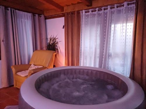 a large bath tub in a room with a chair at Holiday Old stone house in Sveti Ivan Zelina
