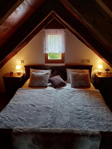 a bedroom with a bed with two pillows and a window at Holiday Old stone house in Sveti Ivan Zelina