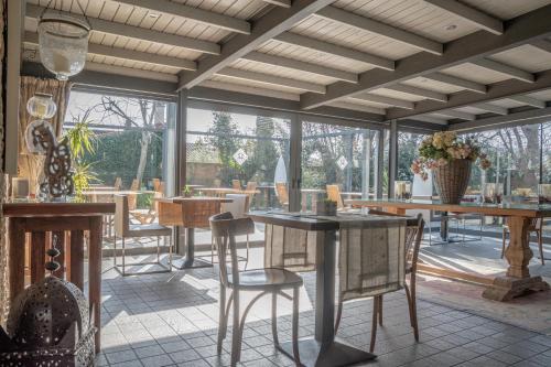 a dining room with tables and chairs and windows at El Racó de Madremanya - Adults only in Madremanya