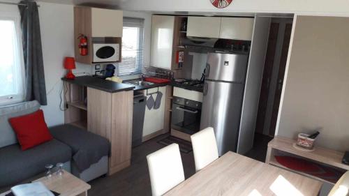 Cette caravane comprend une petite cuisine et un salon. dans l'établissement 526-Charmettes, aux Mathes