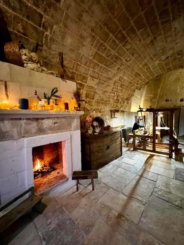 a living room with a fireplace in a stone building at Sextantio Le Grotte Della Civita in Matera