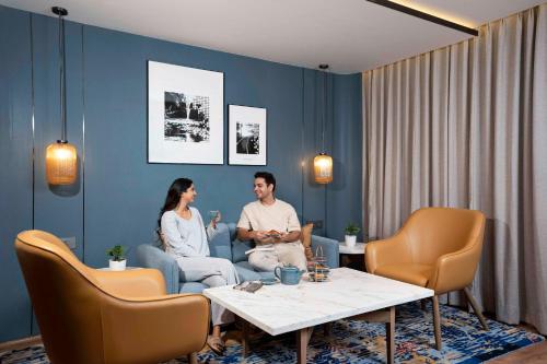 a man and woman sitting on a couch in a room at Radisson Resort Khopoli in Khopoli