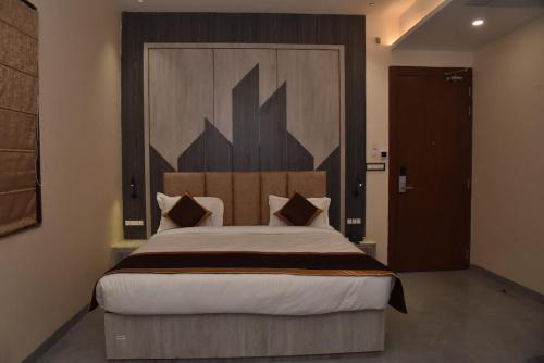 a bedroom with a large bed with a wooden headboard at Hotel JP Inn in Sītāpur