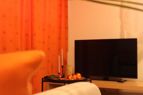 a living room with a tv and a table with candles at Ruhiges, schönes Studio in Zuchwil in Zuchwil