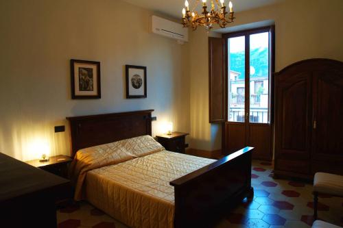 a bedroom with a bed and a window and a chandelier at The Poets' Retreat in Sulmona