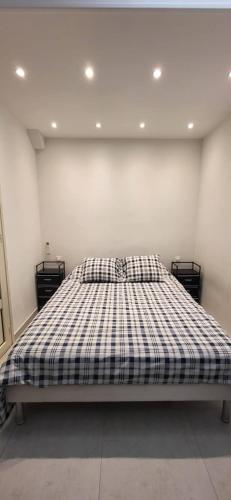 une chambre avec un lit avec une couverture à carreaux dans l'établissement Juan-les-Pins center and beach 50 m away, à Antibes