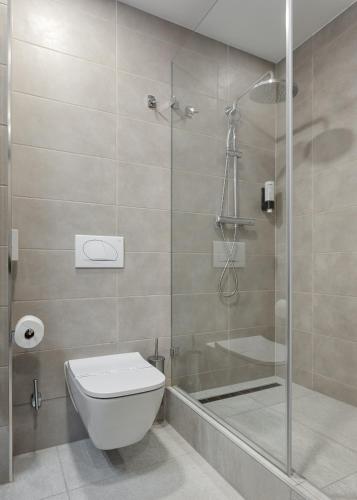 a bathroom with a toilet and a glass shower at Hunguest Hotel Flóra in Eger