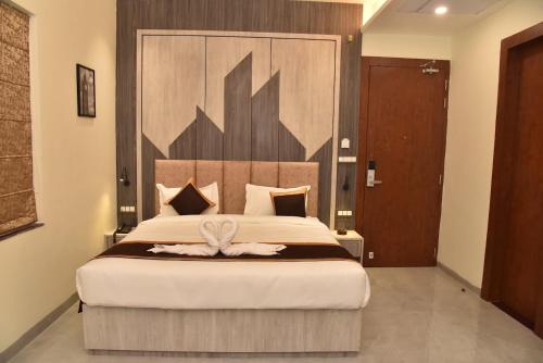 a bedroom with a large bed with a wooden headboard at Hotel JP Inn in Sītāpur