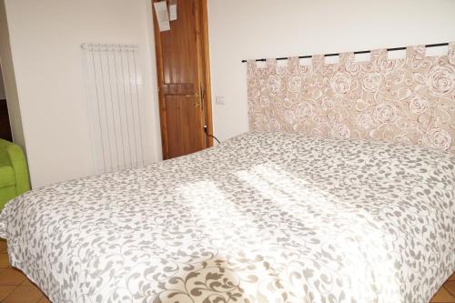 a bedroom with a bed with a white comforter at Camere Sotto le Stelle in Umbertide