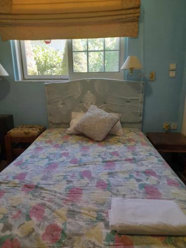 a bedroom with a bed with a colorful quilt at Cozy Christina in Skala Oropou