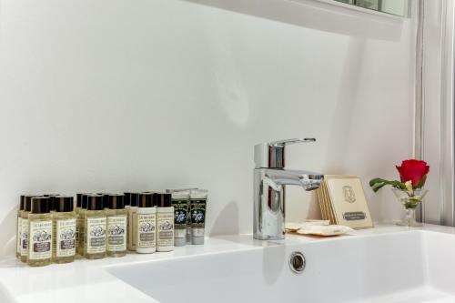 un mostrador blanco con un fregadero con productos. en Sweet Inn - Paix, en París