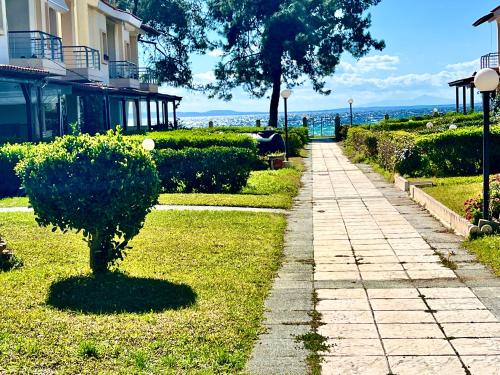 a sidewalk next to a building with a tree at The SeaSide Villas in Nikiti