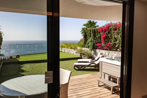 a room with a view of the ocean from a balcony at Serenity Amadores in Puerto Rico de Gran Canaria
