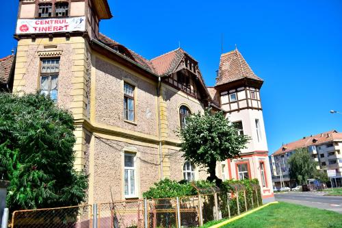 an old building with a tower on a street at White House & Jacuzzi in Sibiu
