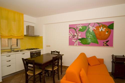 a kitchen and dining room with an orange couch and a table at Residence Degli Agrumi in Taormina