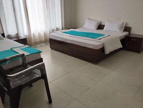 a bedroom with a bed and a chair in it at Sharada Home Stay in Chandrāpuri