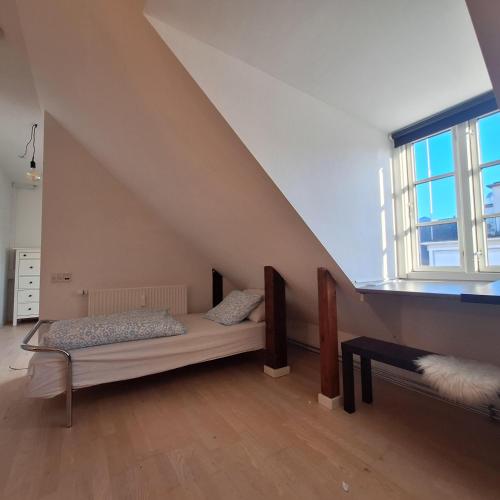a attic room with a bed and a window at Princessen på ærten in Odense