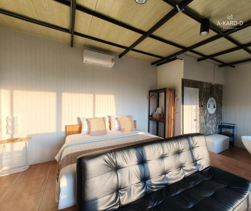 a bedroom with a large bed and a couch at อากาศดีเขาค้อ akardd khaokho in Khao Kho