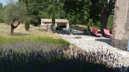 a garden with two chairs and a swimming pool at Villa spacieuse avec jardin à Saignon in Saignon