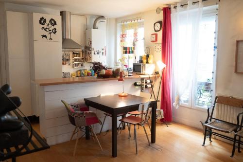 une cuisine avec une table et des chaises dans une pièce dans l'établissement Authentic And Charming Accommodation, à Paris