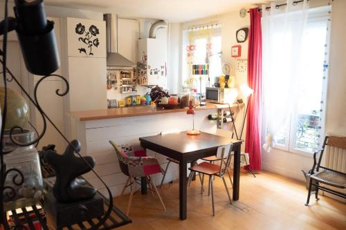 une cuisine avec une table et des chaises dans une pièce dans l'établissement Authentic And Charming Accommodation, à Paris