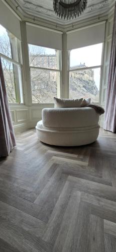 a room with two pillows on a wooden floor with windows at 2 Bedroom Sofa bed in livingroom Castle View 1st floor sleeps 6 in Edinburgh