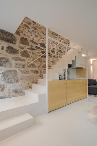a living room with stairs and a stone wall at Casa Dorado in Pontevedra