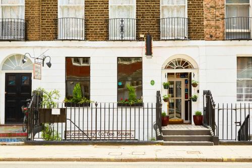 a white building with a black door and a fence at St Athans Hotel in London
