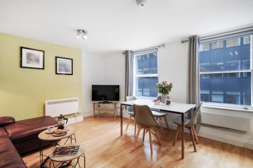 a living room with a couch and a table at Apt 3, Soho Apartments 2nd & 3rd floors by Indigo Flats in London